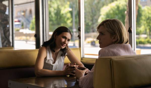 Television still of Karolina Wydra as Zosia, Rhea Seehorn as Carol Sturka in the sci-fi show Pluribus episode "Charm Offensive"