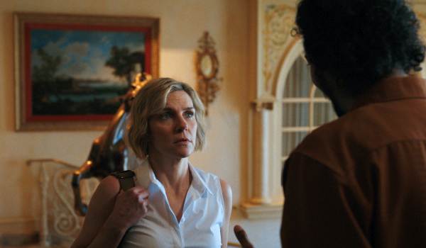Television still of Rhea Seehorn as Carol Sturka, Samba Schutte as Mr. Koumba Diabaté in the Pluribus episode "HDP"