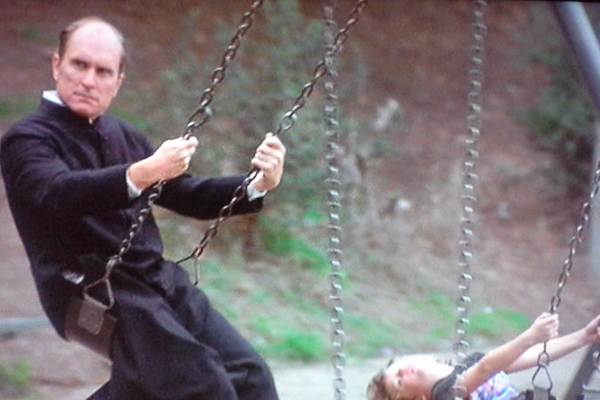 Photo of Robert Duvall as Priest on Swing in Invasion of the Body Snatchers (1978)