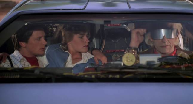 Movie still of Michael J. Fox as Marty McFly, Elisabeth Shue as Jennifer Parker, and Christopher Lloyd as Doctor Emmett Brown riding in the DeLorean in the sci-fi movie Back to the Future Part II (1989)