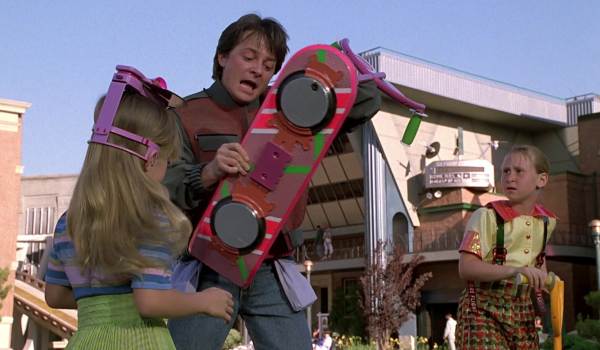 Michael J. Fox as Marty McFly holding a futuristic hoverboard as children look on in the sci-fi movie Back to the Future Part II (1989)