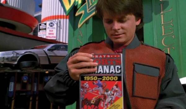Movie still of Michael J. Fox as Marty McFly looking at the Gray's Sports Almanac from the future with the DeLorean in the background in the sci-fi movie Back to the Future Part II (1989)