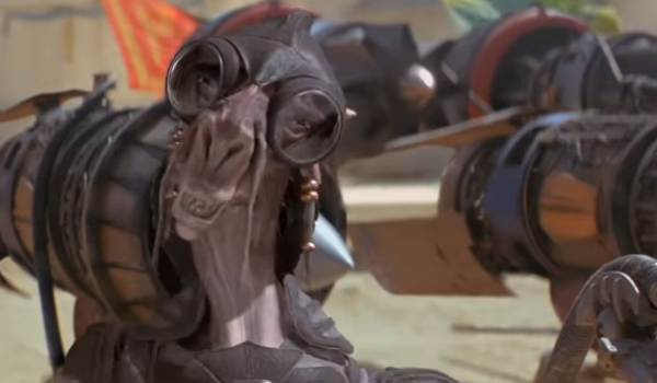 A close-up of Sebulba from Star Wars: Episode I – The Phantom Menace, wearing large goggles and pilot gear with his podracer engines visible in the background.