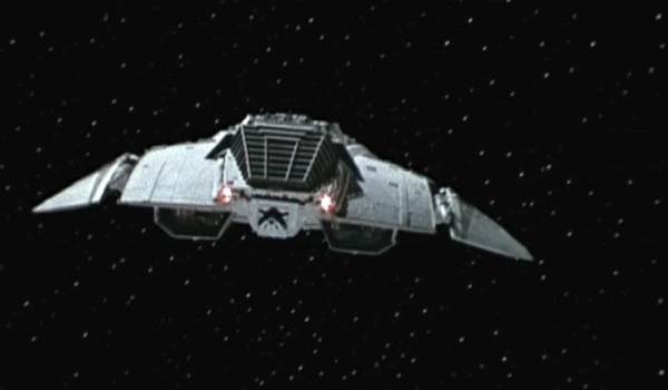 The Battlestar Galactica Cylon starship flying through a field of stars.