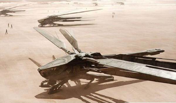 Several Atreides Ornithopters parked on the desert landing field of Arrakeen in a scene from the 2021 film Dune.