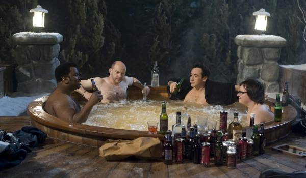 Rob Corddry, Craig Robinson, Clark Duke, and John Cusack relaxing in the titular time-traveling hot tub in a scene from the 2010 film Hot Tub Time Machine.