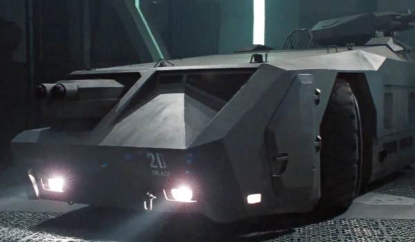  Frontal view of the M577 Armored Personnel Carrier with glowing headlights inside the hangar of the USS Sulaco in Aliens.