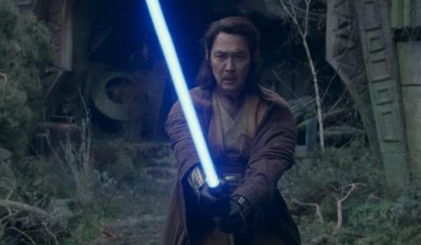 Jedi Master Sol (Lee Jung-jae) stands in a defensive stance with his blue lightsaber ignited in the 2024 series The Acolyte.
