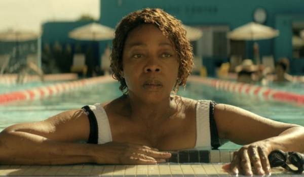Alfre Woodard as Judy Daniels swimming in a pool during the sci-fi show The Boroughs