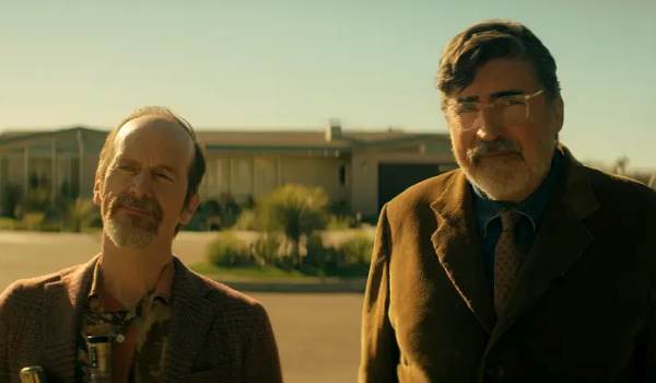 Denis O'Hare and Alfred Molina standing outside in a desert retirement community in a scene from Netflix's The Boroughs.