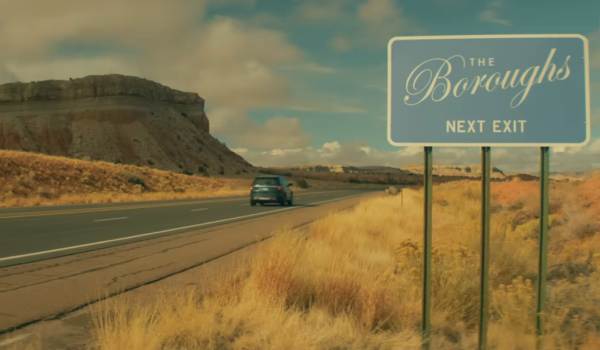 A car driving down a road in New Mexico passing a sign that reads "The Buroughs"