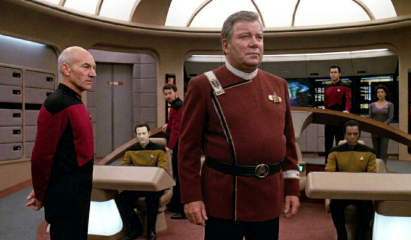 An AI-generated image of William Shatner as an older Captain James T. Kirk in a red Starfleet uniform standing on the bridge of the USS Enterprise-D alongside Patrick Stewart as Captain Jean-Luc Picard and the crew of Star Trek: The Next Generation.
