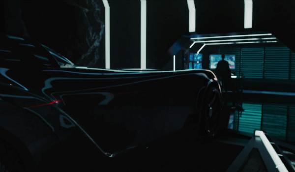 Flashback of Robin in the dark Batcave next to the Batmobile