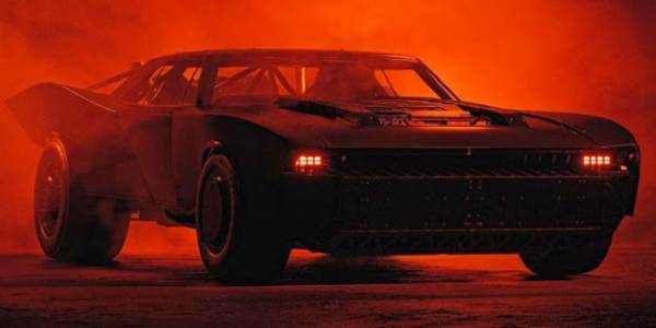 Dark image of the Batmbobile from The Batman (2022) shrouded in darkness and mist with red lights