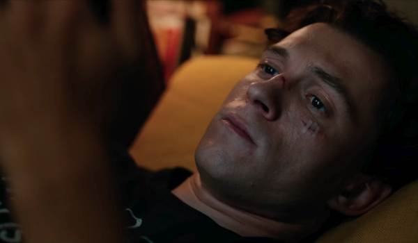 Close-up of actor Tom Holland as a bruised and weary Peter Parker in a scene from Spider-Man: Brand New Day.