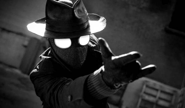 Television still of Nicolas Cage as Ben Reilly/The Spider pointing his hand to shoot a spider web in the superhero show Spider-Noir
