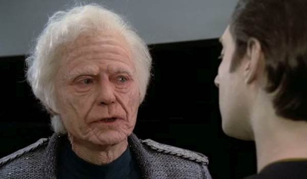 An elderly Admiral Leonard McCoy speaking to Lieutenant Commander Data.