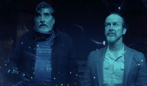 Alfred Molina as Sam Cooper and Denis O'Hare as Wally Baker look at a shower of lights that look like stars in the sci-fi show The Boroughs episode '"The Mourning After"