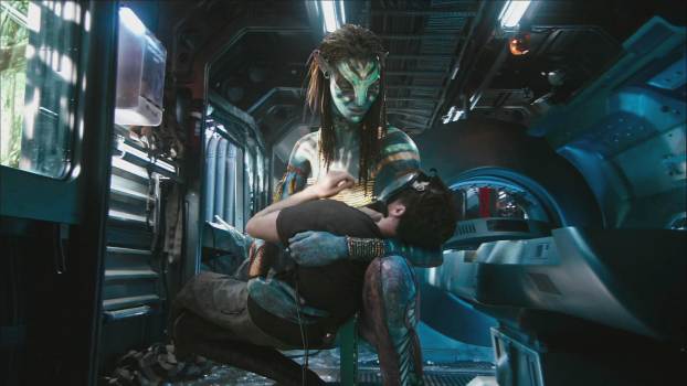 Neytiri, played by Zoe Saldaña, holding the unconscious human body of Jake Sully, played by Sam Worthington, inside an Avatar link unit in the science fiction movie Avatar (2009).