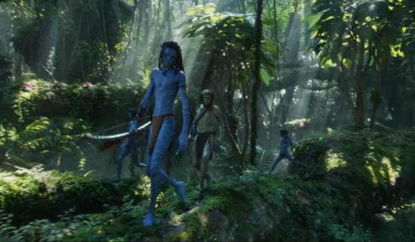 A group of Na'vi warriors trekking through the lush Pandoran forest alongside the human character Spider in the science fiction movie Avatar: The Way of Water (2022).