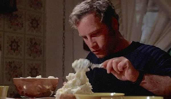 Richard Dreyfuss as Roy Neary sculpting a mountain out of mashed potatoes in the classic American sci-fi film Close Encounters of the Third Kind.