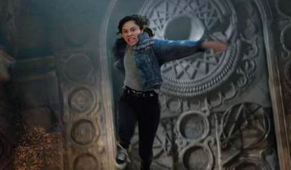 Xochitl Gomez as America Chavez jumping with a determined expression in the Marvel movie Doctor Strange in the Multiverse of Madness.