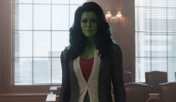 Tatiana Maslany as Jennifer Walters in her She-Hulk form, wearing professional business attire in a courtroom setting from the Marvel series She-Hulk: Attorney at Law.