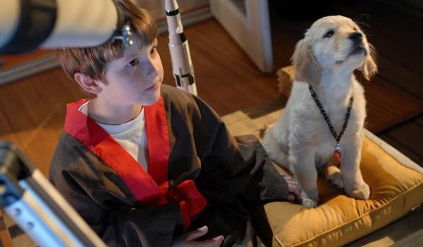 Nolan Gould as Sam and Bud the Golden Retriever puppy in a scene from Space Buddies.