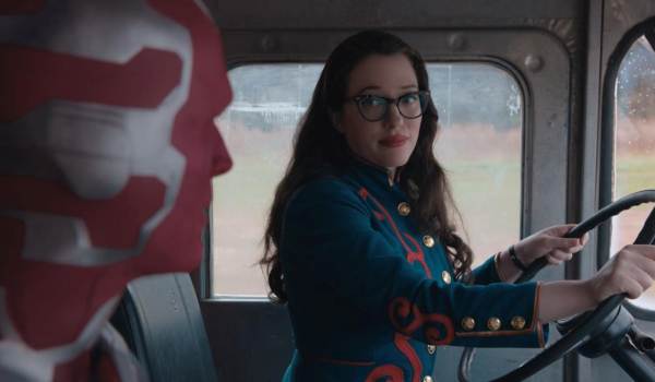 Kat Dennings as Darcy Lewis driving a vehicle while looking at Paul Bettany as Vision in the passenger seat in the series WandaVision.