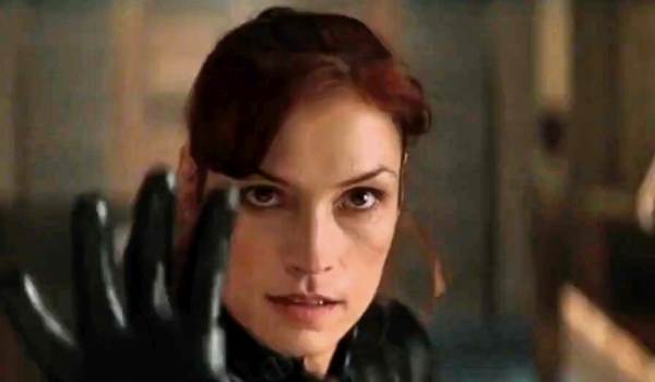 Alt text: Famke Janssen as Jean Grey holding up a gloved hand in X-Men.